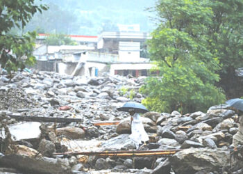 Locals walk across a makeshift bamboo and wooden crossing